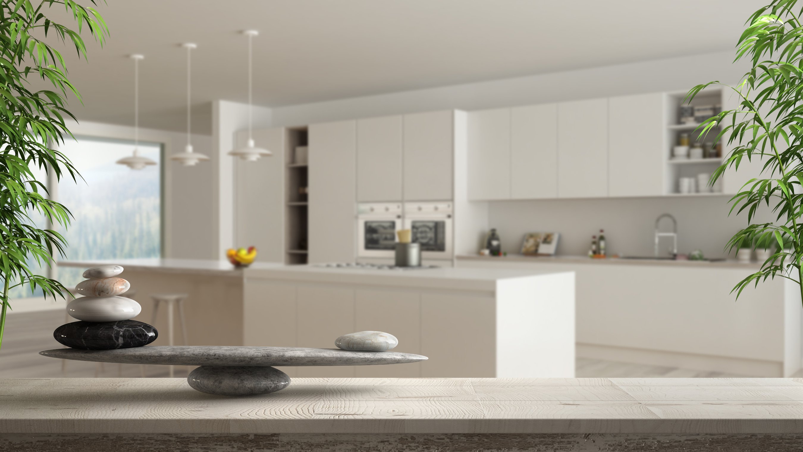 Wooden vintage table or shelf with stone balance, over blurred minimalist white and wooden kitchen with island and big panoramic window, feng shui, zen concept architecture interior design